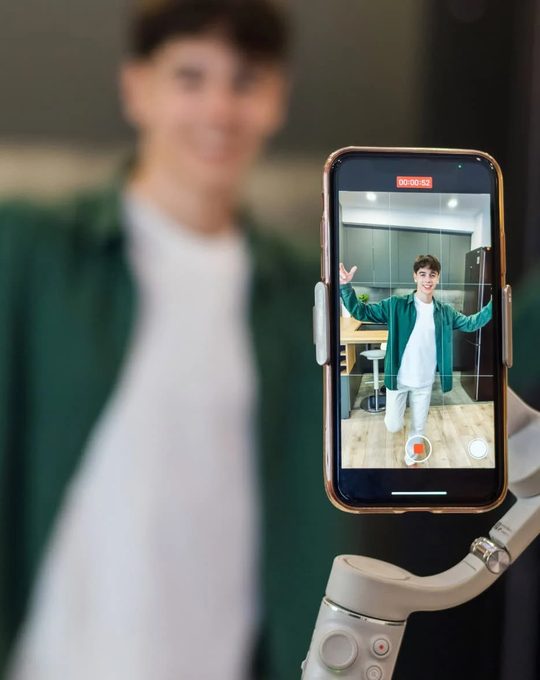 Small business owner recording a short promotional video on a phone mounted on a gimbal