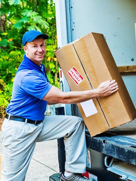Local Services: friendly delivery man carrying a parcel to a customer's door