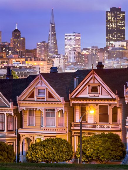 Places to Live: row of colorful historic homes in front of a city skyline