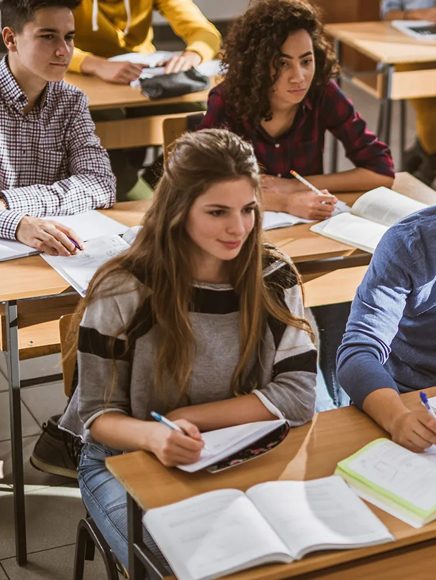 Schools and Education: students writing in notebooks in a classroom